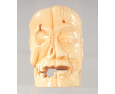 A JAPANESE CARVED BONE NETSUKE, modelled as a head. 5.5ins long.