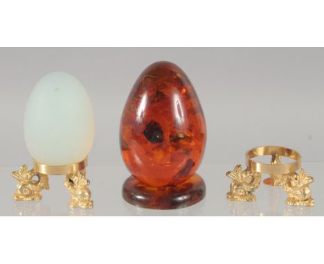 A PAIR OF OPAL AND AMBER EGGS on a stand.