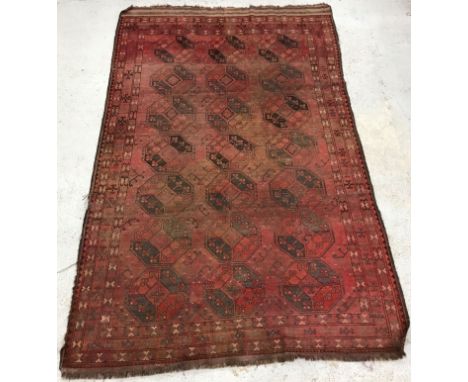 A Bokhara rug, the central panel set with repeating medallions on a red ground within a stepped red and black geometric patte