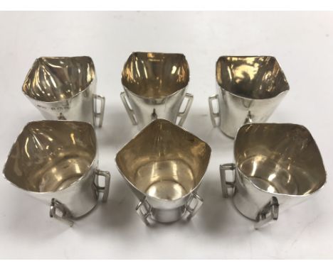A set of six Edwardian silver tot cups of tapering form, raised on four openwork supports ( five by James Wood &amp; Sons, Bi