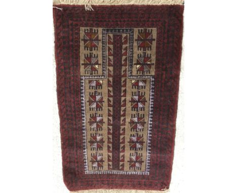 A Belouch prayer rug, the central panel set with geometric design on a mushroom ground, within a stepped red and black geomet