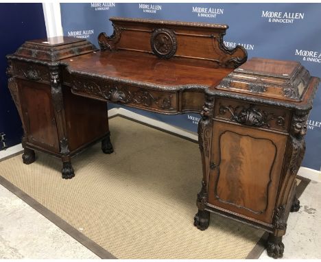 A mahogany Classical Revival breakfront sideboard, the centre section with plain top and raised back depicting a bird eating 