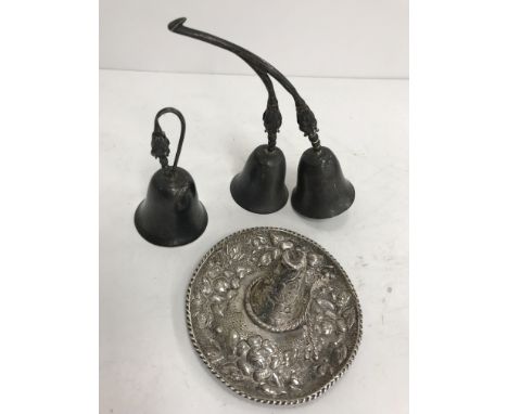 A Mexican embossed sterling silver sombrero 9.5 cm diameter, a pair of Mexican sterling silver bells with floral decoration a