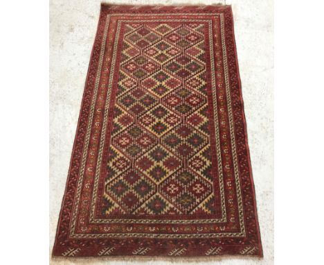 A Bokhara type rug, the central panel set with repeating lozenge medallions on a red and cream ground within a red and cream 