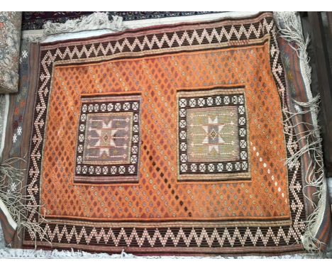 A Kelim rug, the central panel set with two rectangular medallions on an orange ground within a stepped brown and orange zig 