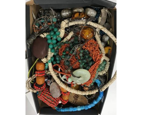 A box of various costume jewellery including shark vertebrae necklaces, jade bead necklace, malachite bead necklace, coral ne
