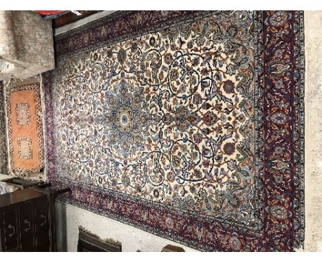 A Kashan carpet, the central panel set with floral and hook motif decorated medallion on a cream ground with scrolling foliat