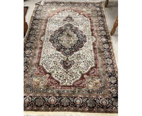 An Oriental carpet, the central panel set with floral decorated medallion on a blue and cream foliate decorated ground, withi