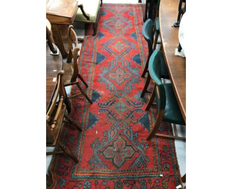 A Donegal type runner, the central panel set with scrolling design on a red ground within a red, blue, green and orange stepp