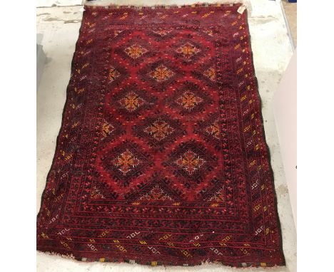 A Bokhara type rug, the central panel set with repeating lozenge medallions on a red ground within a stepped red and black bo