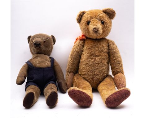 An early to mid 20th century blonde mohair plush teddy bear, with boot button eyes, remnants of a black stitched nose, a pink