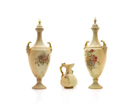 A pair of Royal Worcester porcelain vases painted with foliate sprays to a blush ivory ground with gilt heighted details,32cm