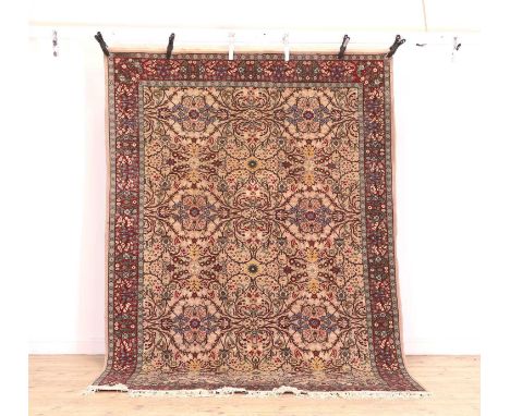 A Turkish Hereke wool rug, 20th century, with foliate decoration to a pale pink field, with burgundy foliate borders,285cm x 