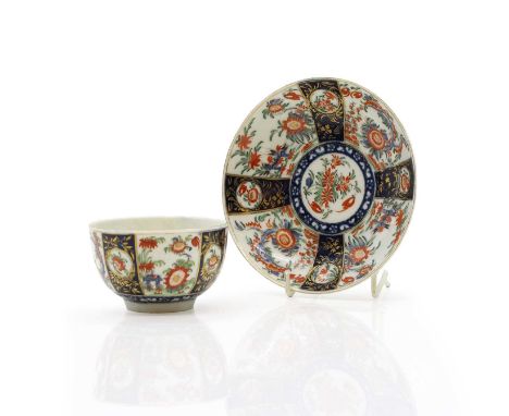 A First Period Worcester porcelain teacup and saucer, c.1770, 'Rich Queens' pattern, with floral and gilt decoration painted 