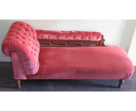 A late Victorian button down upholstered chaise longue on turned legs.
