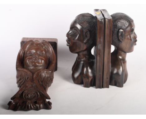 A pair of African rosewood bookends carved male and female heads, 9" high, and a wooden bracket carved cherub, 11" high