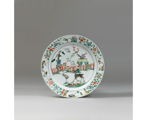 A LARGE PAINTED WUCAI ‘DEER AND CRANE’ DISH KANGXI (1662-1722) The shallow rounded sides resting a short tapered foot, the in