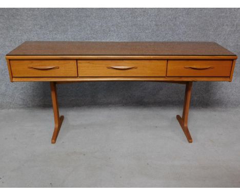 A 1970's vintage teak console sideboard fitted with frieze drawers on platform supports. H.71 W.154 D.43cm 