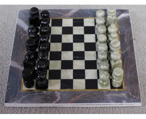 A vintage boxed Turkish carved hardstone chessboard and pieces. The pieces are made from a pale green hardstone and black pai