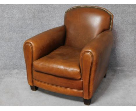 A vintage style club armchair in tan leather studded upholstery. H.86 W.82 D.90cm 