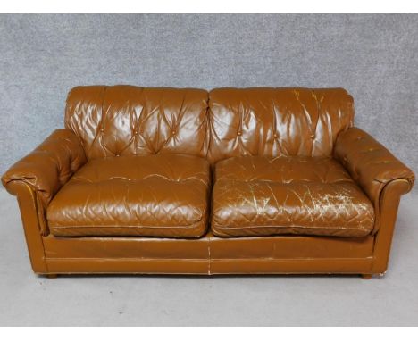 A vintage brown leather upholstered button backed two seater sofa. H.70 W.170 D.90cm 