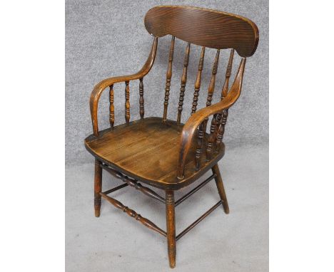 An American Colonial style oak stick back armchair on turned stretchered supports. H.88cm 