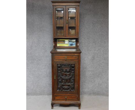 A late 19th century oak two section cabinet with well carved classical style panel door. H.211 W.59 D.45cm