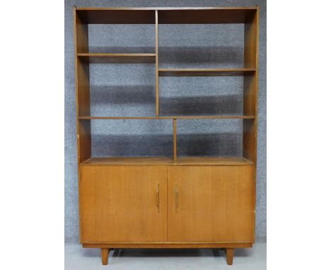 A 1960's vintage teak open bookcase with panel doors to the base. H.178 W.122 D.30cm 