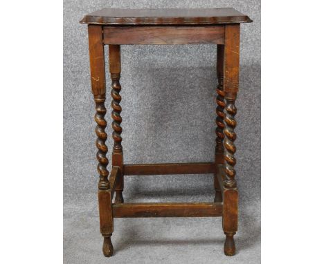 A mid 20th century oak lamp table on stretchered barley twist supports. H.73 L.46 W.47cm