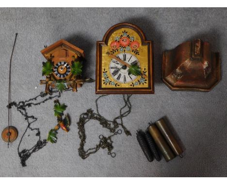 Two vintage Continental wall clocks and a painted plaster plinth base. One clock is a carved wooden cuckoo clock with pop out