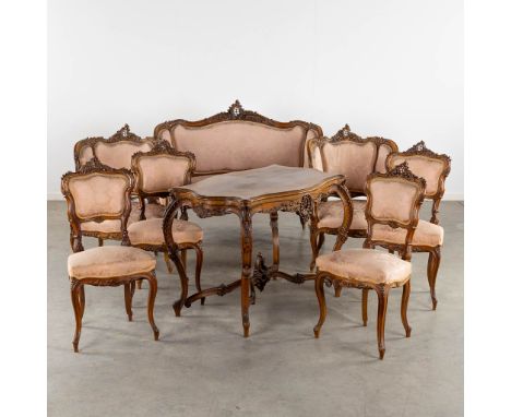 An 8-piece salon suite, sculptured wood in Louis XV style. Circa 1900.Two-person sofa, two armchairs, four chairs and a table