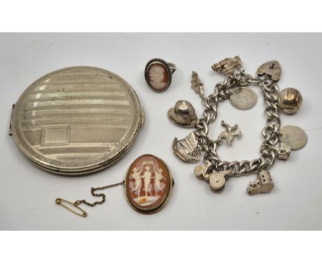 A silver curb link charm bracelet, suspending various charms and coins, together with an engine turned circular silver compac