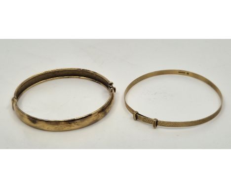 A 9ct. gold hinged bangle, engraved floral design to exterior, together with a 9ct. gold engine turned bangle. (total 13.1g).