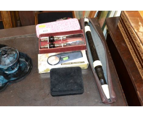 A magnifying glass, recorder in case, two butter knives etc.