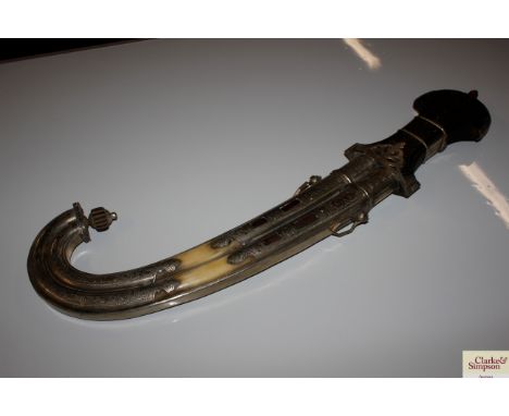 A massive Indian Khaye Jambyo dagger in white metal and horn mounted wooden scabbard 
