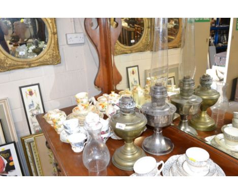 A brass oil lamp and glass chimney; and a metal ware similar