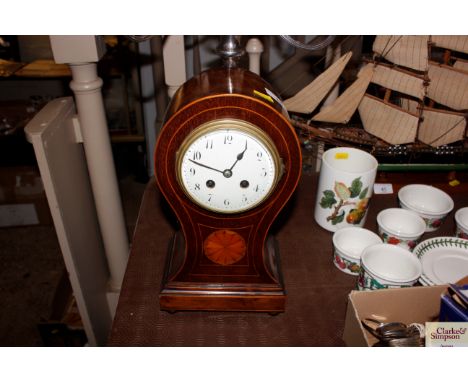 An Edwardian mahogany and boxwood strung balloon shaped two hole mantel clock 