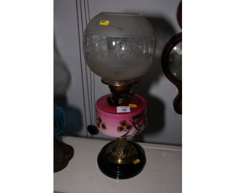 A Victorian pedestal oil lamp with pink floral painted glass reservoir and brass stand with etched glass shade