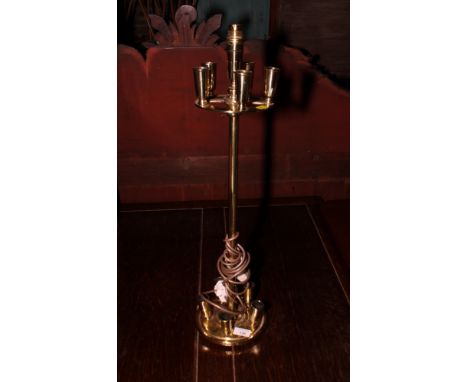 A circular brass ten-light candle holder in the style of Christopher Dresser, fitted as a table lamp