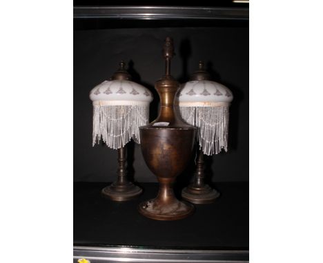 A pair of bronzed table lamps with white glass Art Nouveau shades decorated fringes and another urnular bronzed table lamp