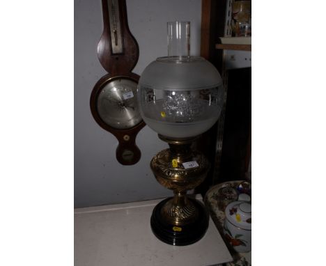 A Victorian embossed brass pedestal oil lamp with chimney and etched glass shade