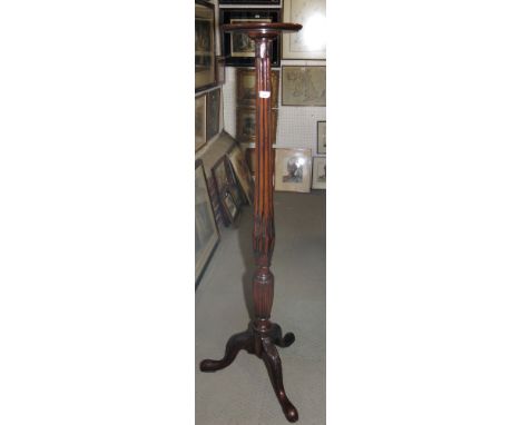 A mahogany jardinière stand of Sheraton design with reeded shaped column, on carved tripod splay supports, 59" high