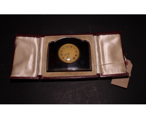 A travelling clock in silver and tortoiseshell frame with travelling case (support strut missing)