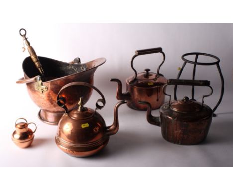Three copper kettles, a kettle stand, a jersey jug, a copper cream skimmer and a coal helmet