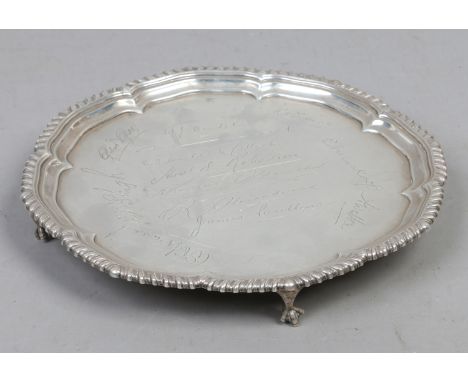 A heavy gauge presentation silver salver with gadrooned decoration raised on four claw feet by Harrison Brothers and Howson, 