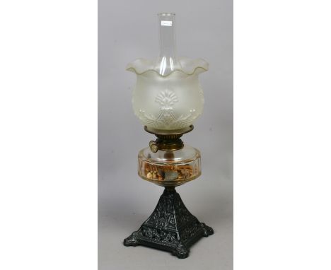 A Victorian cast iron based oil lamp clear glass font and milchglas shade.