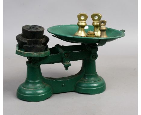 A set of vintage weighing scales along with a collection of brass and iron weights.