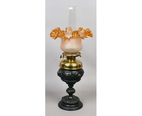 A Victorian brass and cast iron oil lamp with milchglas and amber coloured glass shade.