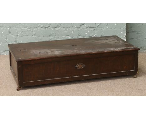 An oak under bed trunk on casters.