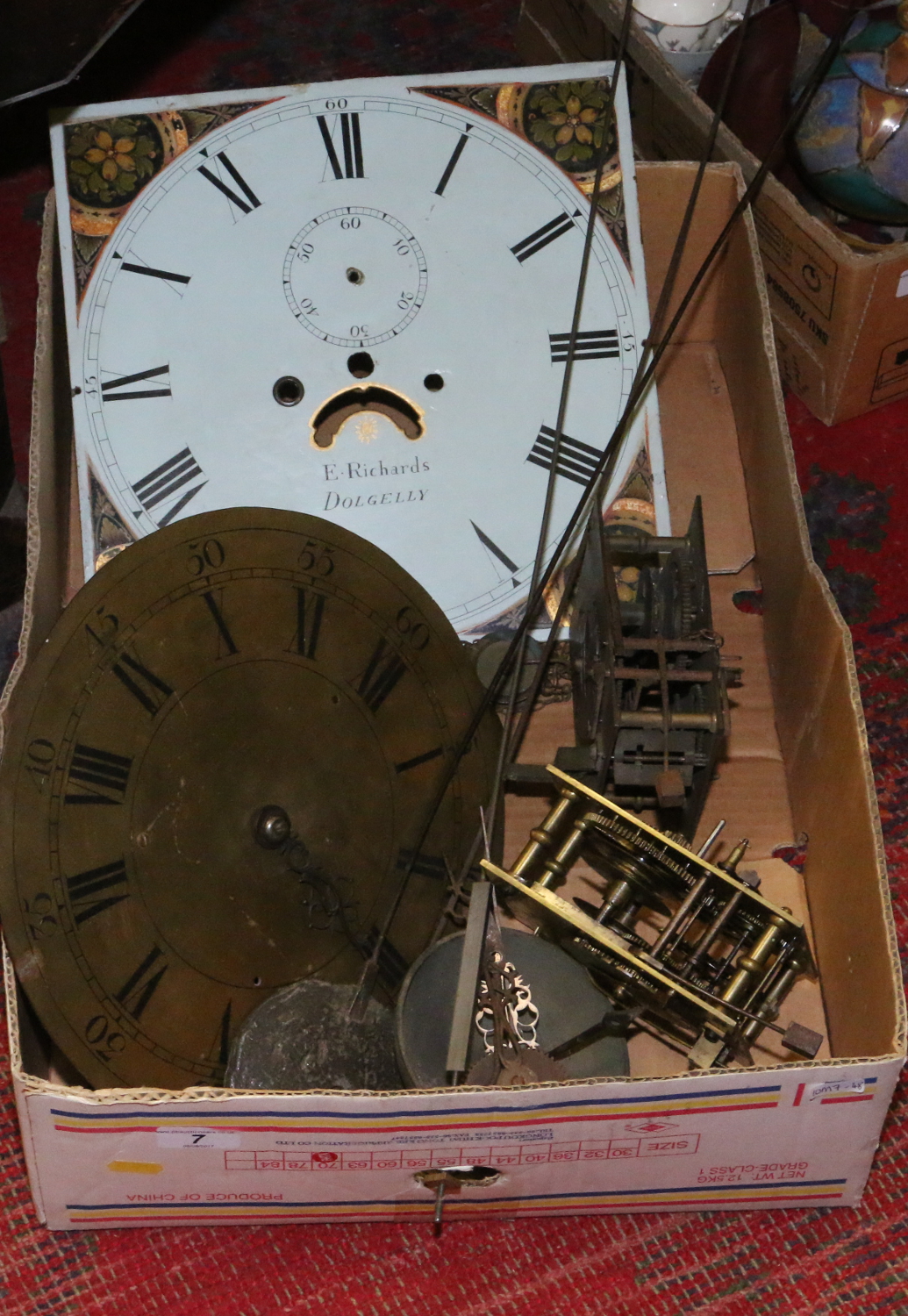 A box of antique clock parts including brass and painted longcase dials